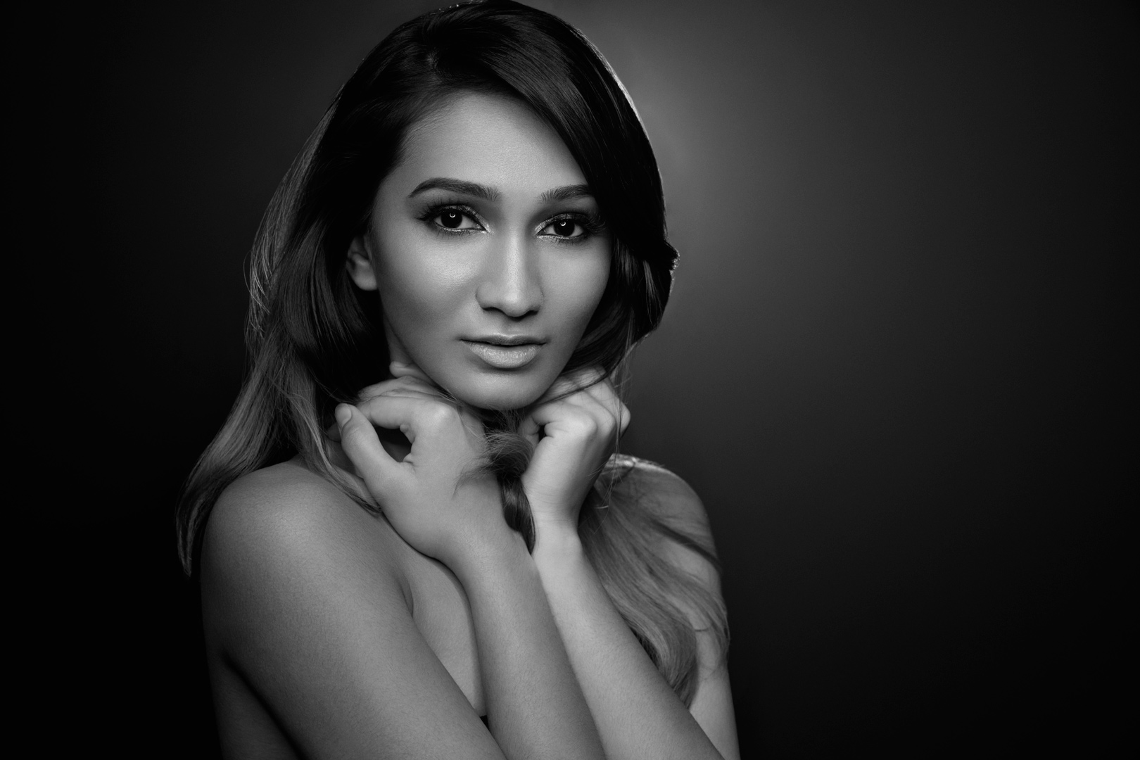 Black and white beauty portrait with soft lighting and hands framing the face