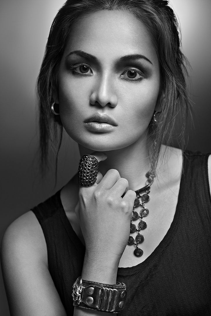 Black and white beauty portrait with statement ring, coin necklace, and leather bracelet