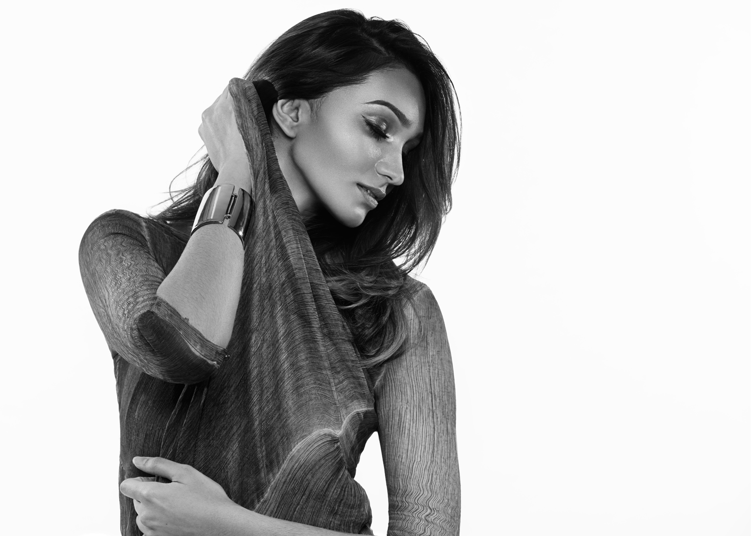 Black and white fashion portrait in textured long-sleeve top with silver cuff bracelet, profile view